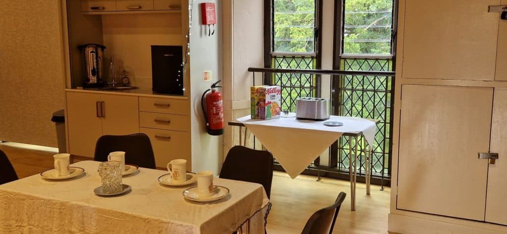 A table near a window, with cereal box and toaster.